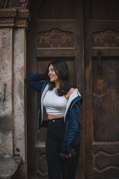 Brunette Woman Standing in Front of Wooden Door 