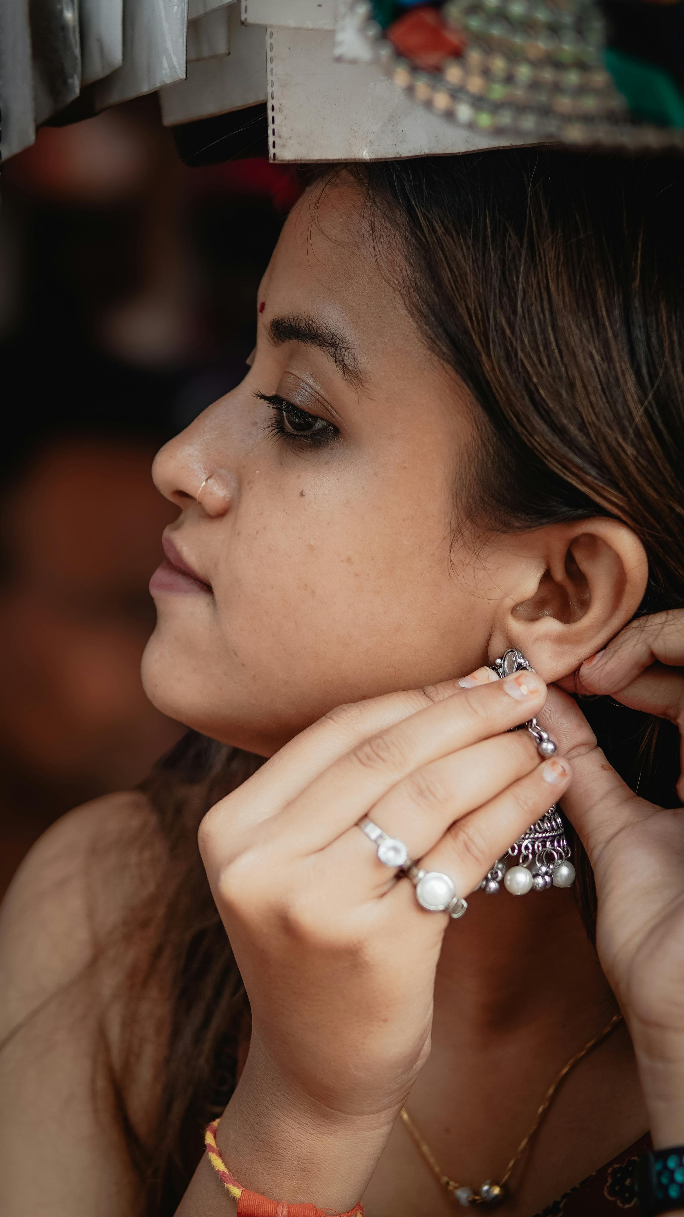 Premium Photo | Close up of an attractive woman putting on diamond earrings