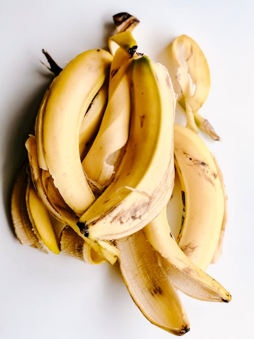 Желтые банановые кожуры на белой поверхности
