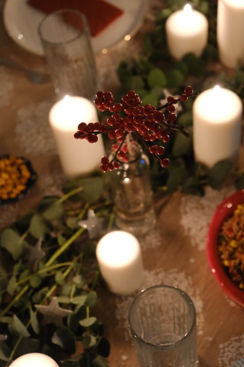 Free A cozy dinner table setting with berries, candles, and elegant decor for a festive occasion. Stock Photo