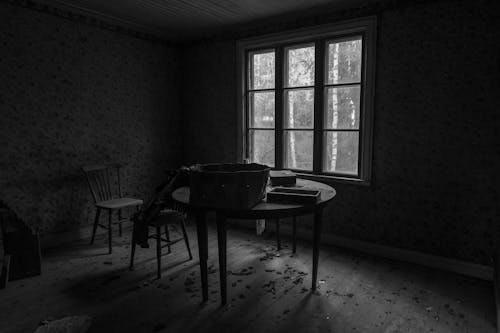 Table and Chairs by Windows in Abandoned House