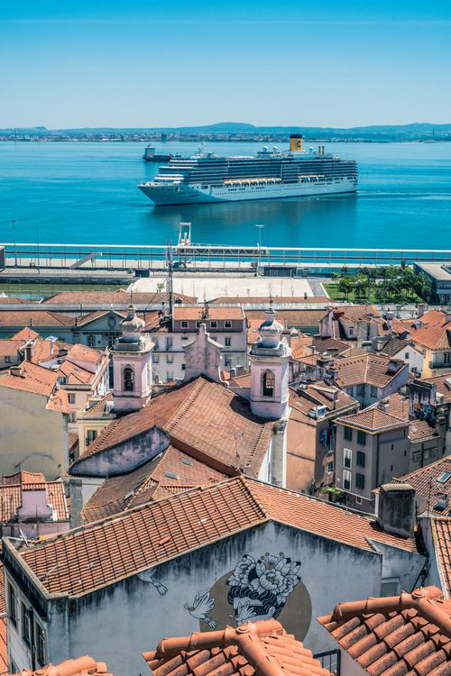 Ferry docked in a harbor in Portugal with Lisbon cityscape and Tagus River under a clear sky