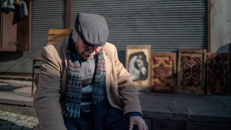 Elderly Man Selling Paintings On A Street 