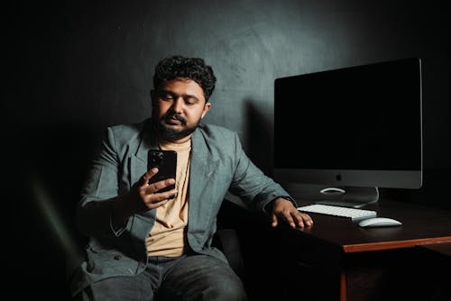 Bearded Brunette with Smartphone in Office