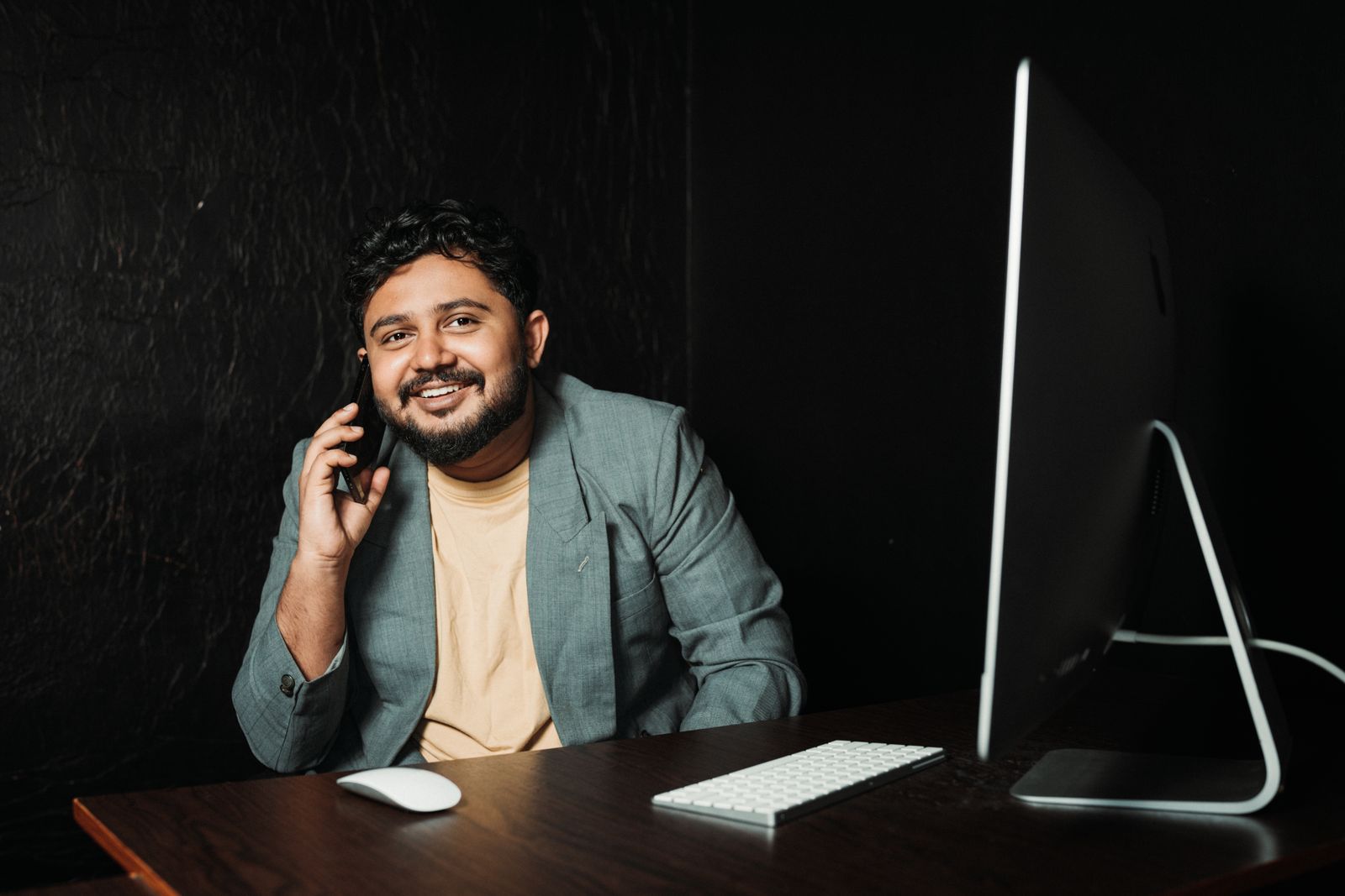 Business owner using a smartphone at a desk in a modern office