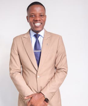 Businessman in beige suit smiling confidently, showcasing elegance and professionalism.