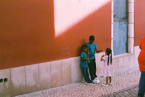 Free A group of children standing in front of a wall Stock Photo