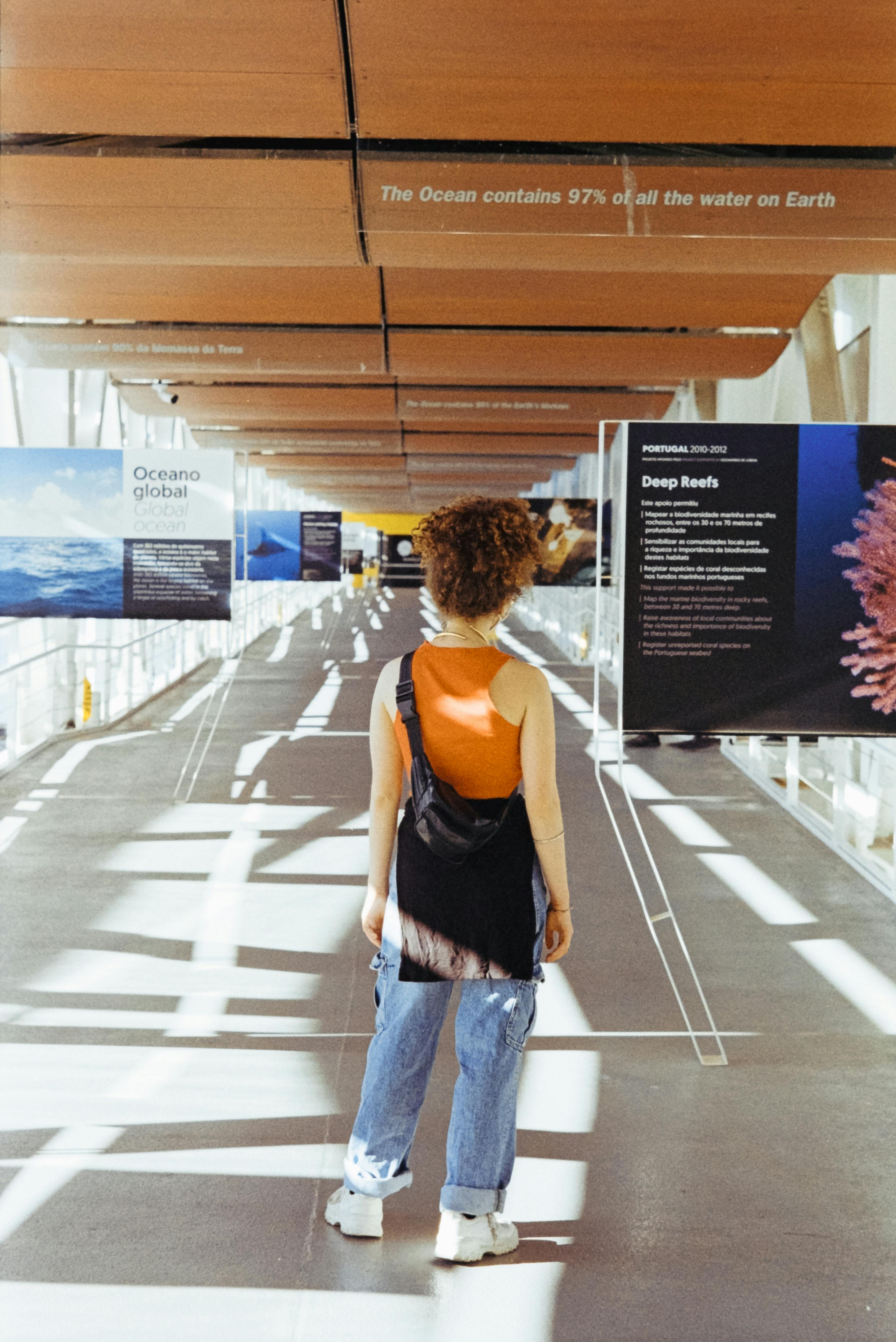 Back view of a woman exploring an exhibition on oceanography in Lisbon, Portugal.