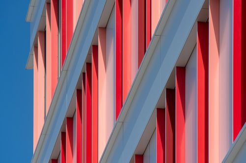 Free Dynamic red and white architectural facade showcasing modern urban design. Stock Photo