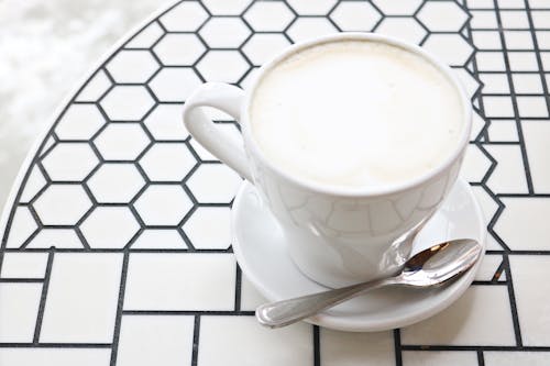 Free White Ceramic Teacup With Saucer and Stainless Steel  Teaspoon Stock Photo