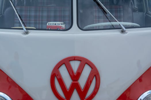 Close-up of a vintage Volkswagen bus front showing its iconic logo and window reflections.