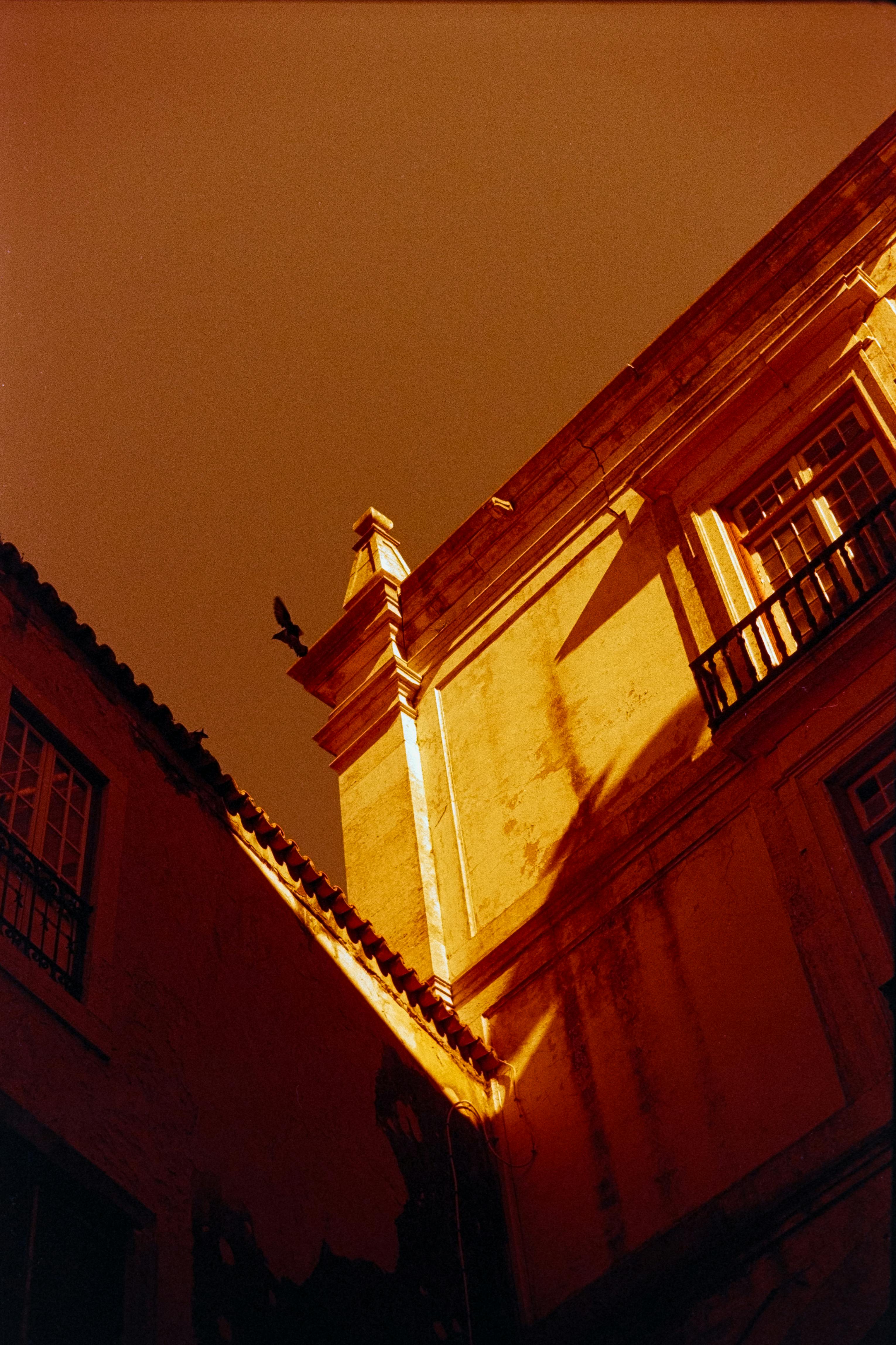 Sunlit urban architecture casting dramatic shadows in Lisbon, Portugal.