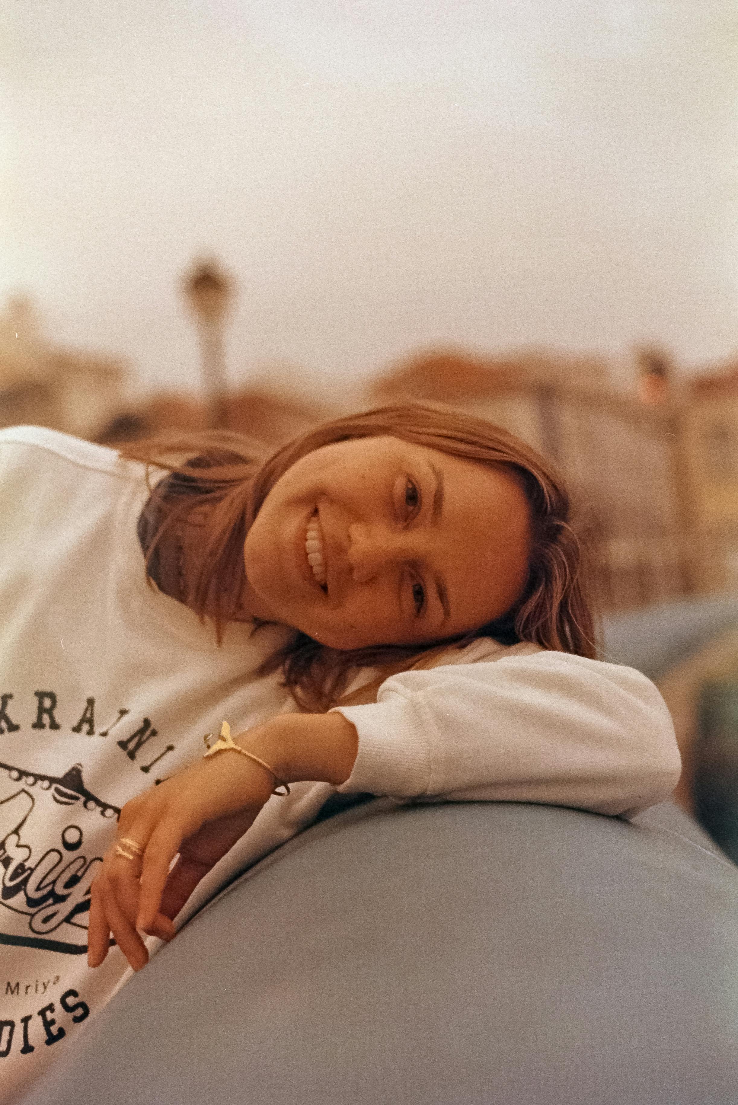 A happy young woman with a radiant smile enjoying a sunny day outdoors in Ericeira, Portugal.