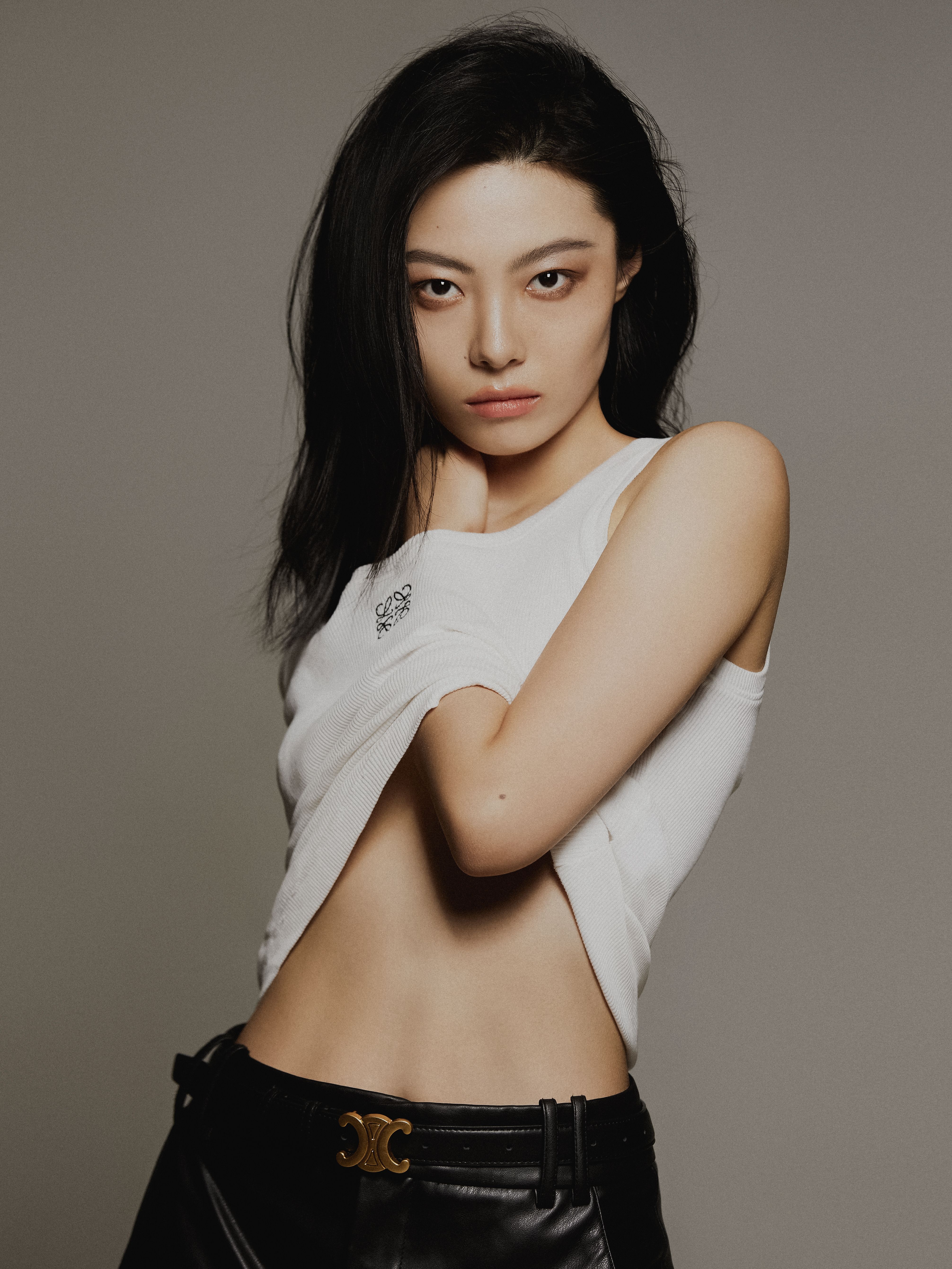 Elegant portrait of a woman posing in a studio, showcasing fashion and style.