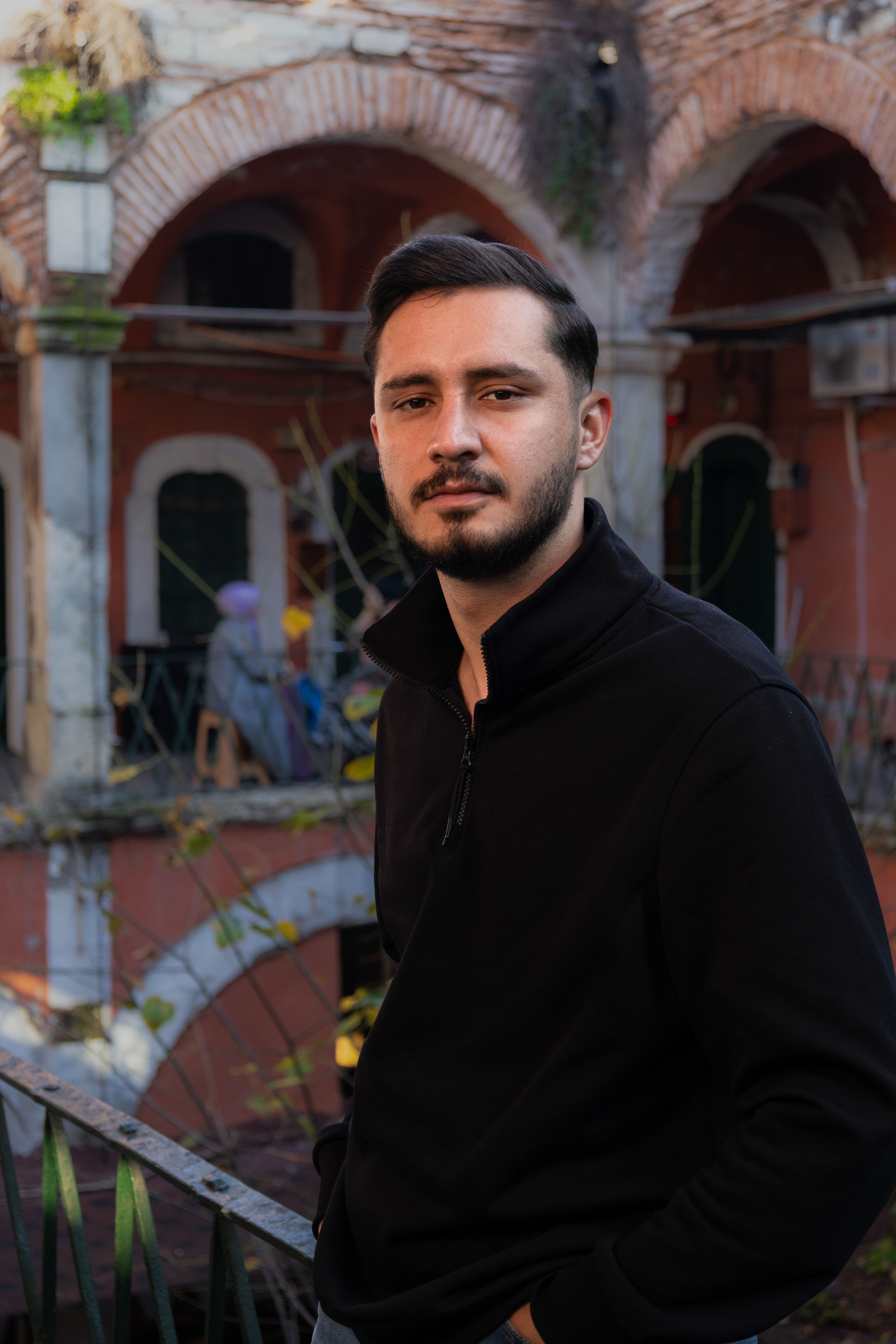 A man in black sweater standing in front of a building · Free Stock Photo