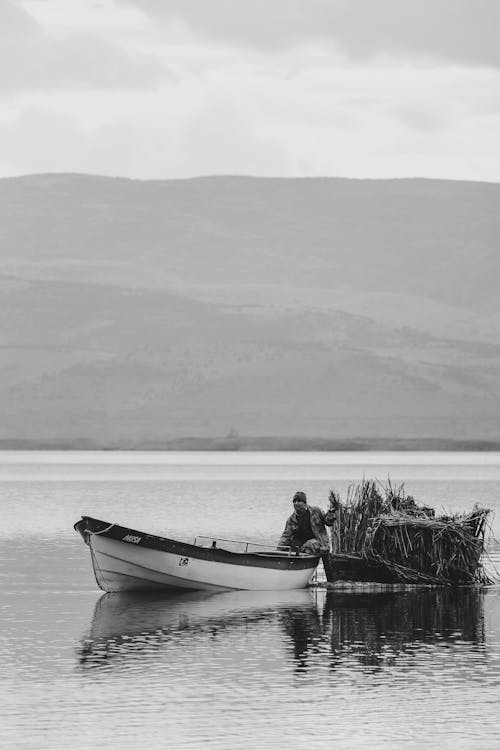 Man Sitting Alone on Boat on Lake