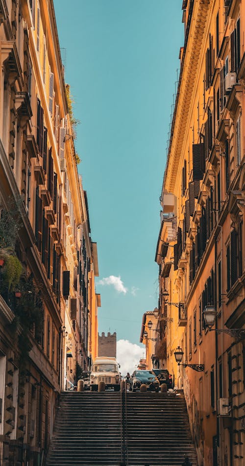 A narrow street with buildings and cars