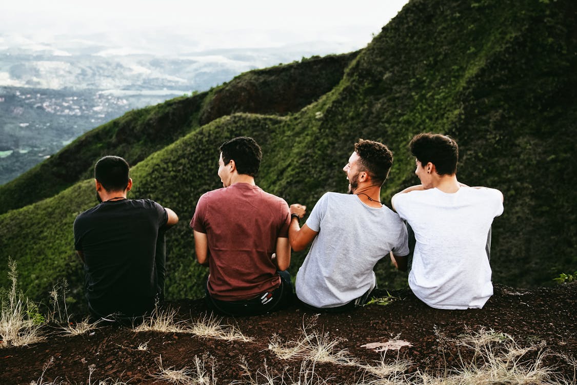 Four Men Sitting On Ground.