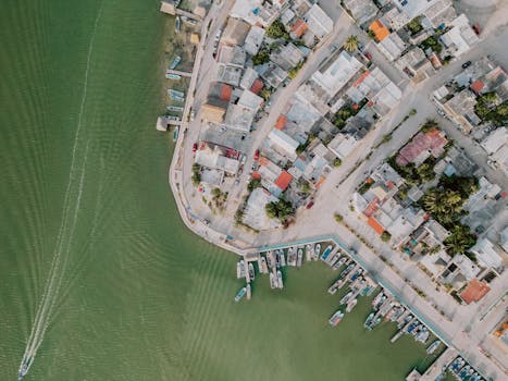 Drone shot capturing colorful rooftops and boats at Río Lagartos harbor, Mexico.