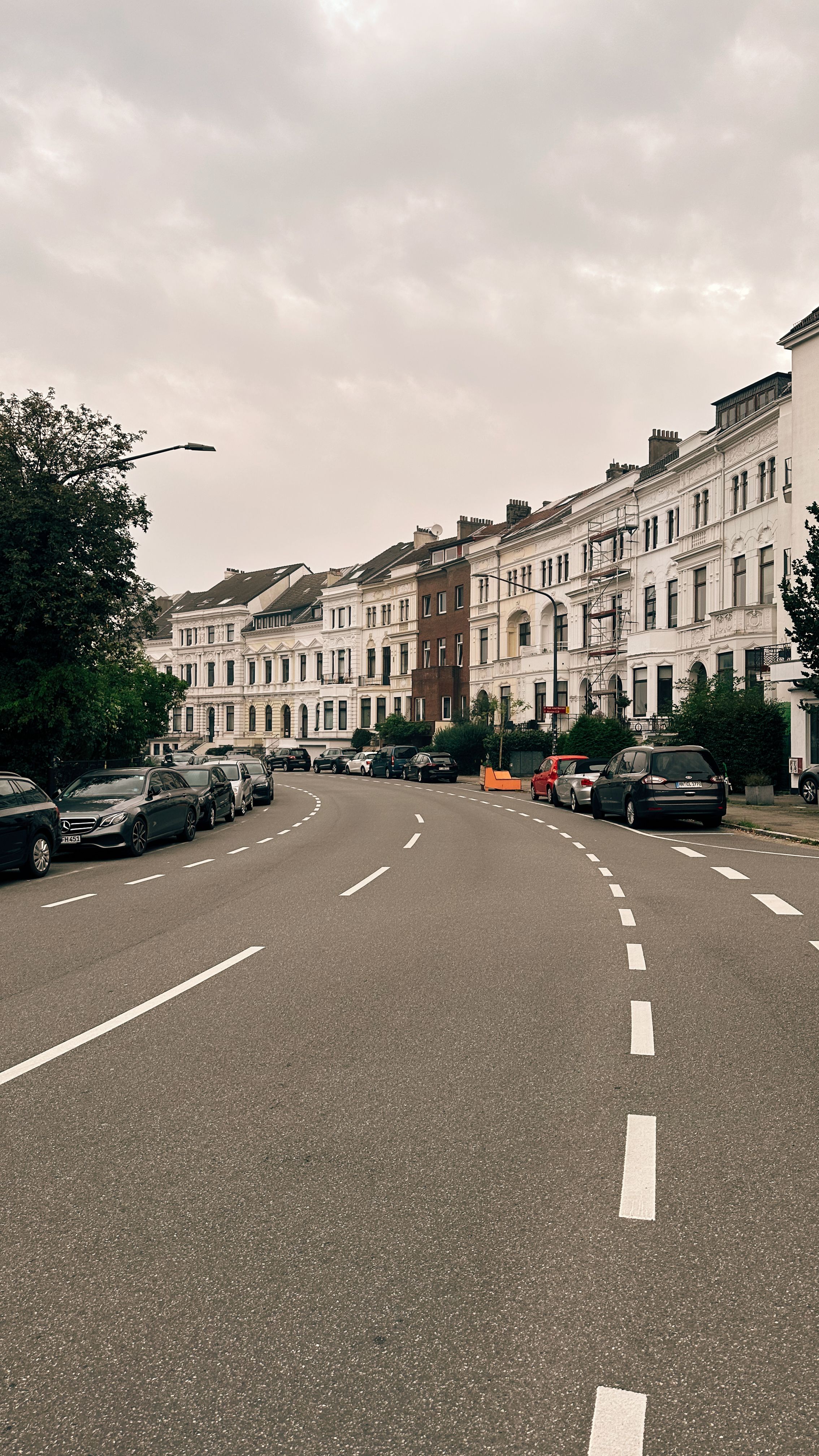 A street with cars parked on both sides · Free Stock Photo