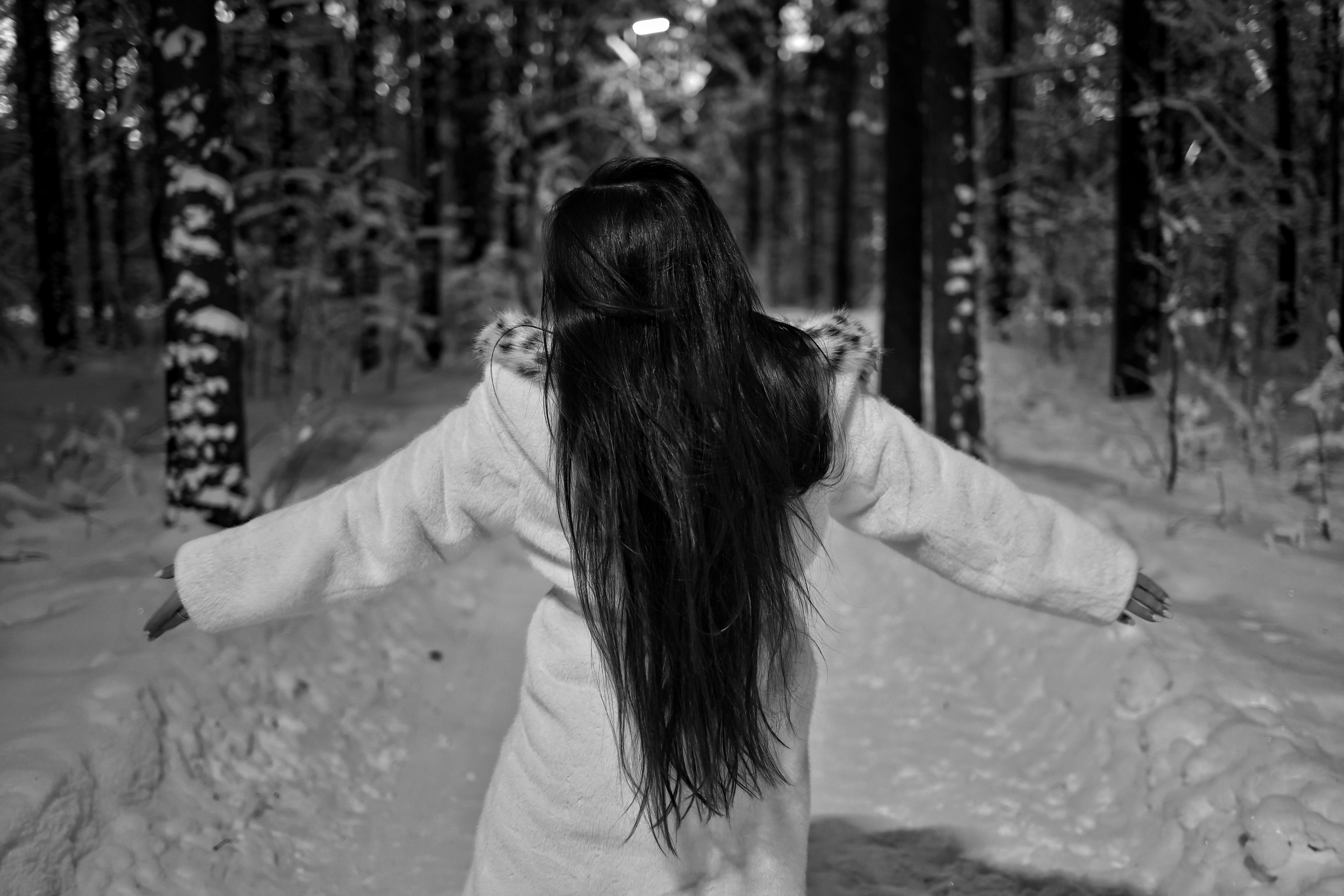 Back View of a Woman with Long Hair Standing in a Snowy Forest with ...