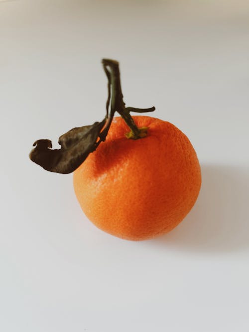 Close-up of a Tangerine with a Dry Leaf 