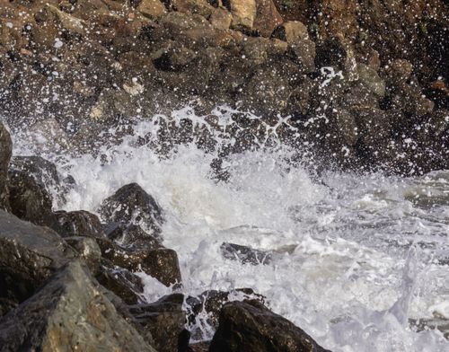 Free Dramatic scene of ocean waves crashing over rocky shoreline, creating a powerful splash. Stock Photo