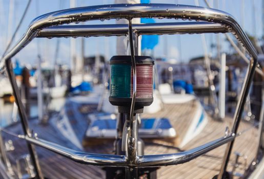 Detailed view of metal yacht with navigational lights in sunny marina harbor.