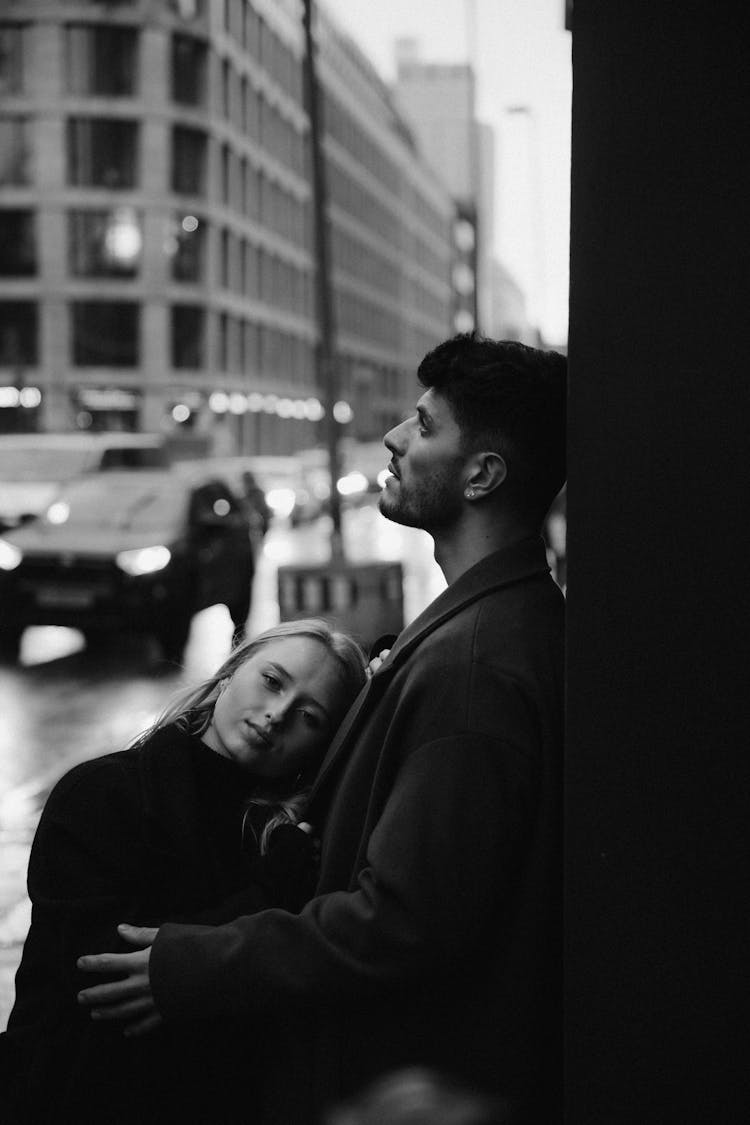 Embracing Couple On The Sidewalk On A Cold Rainy Day