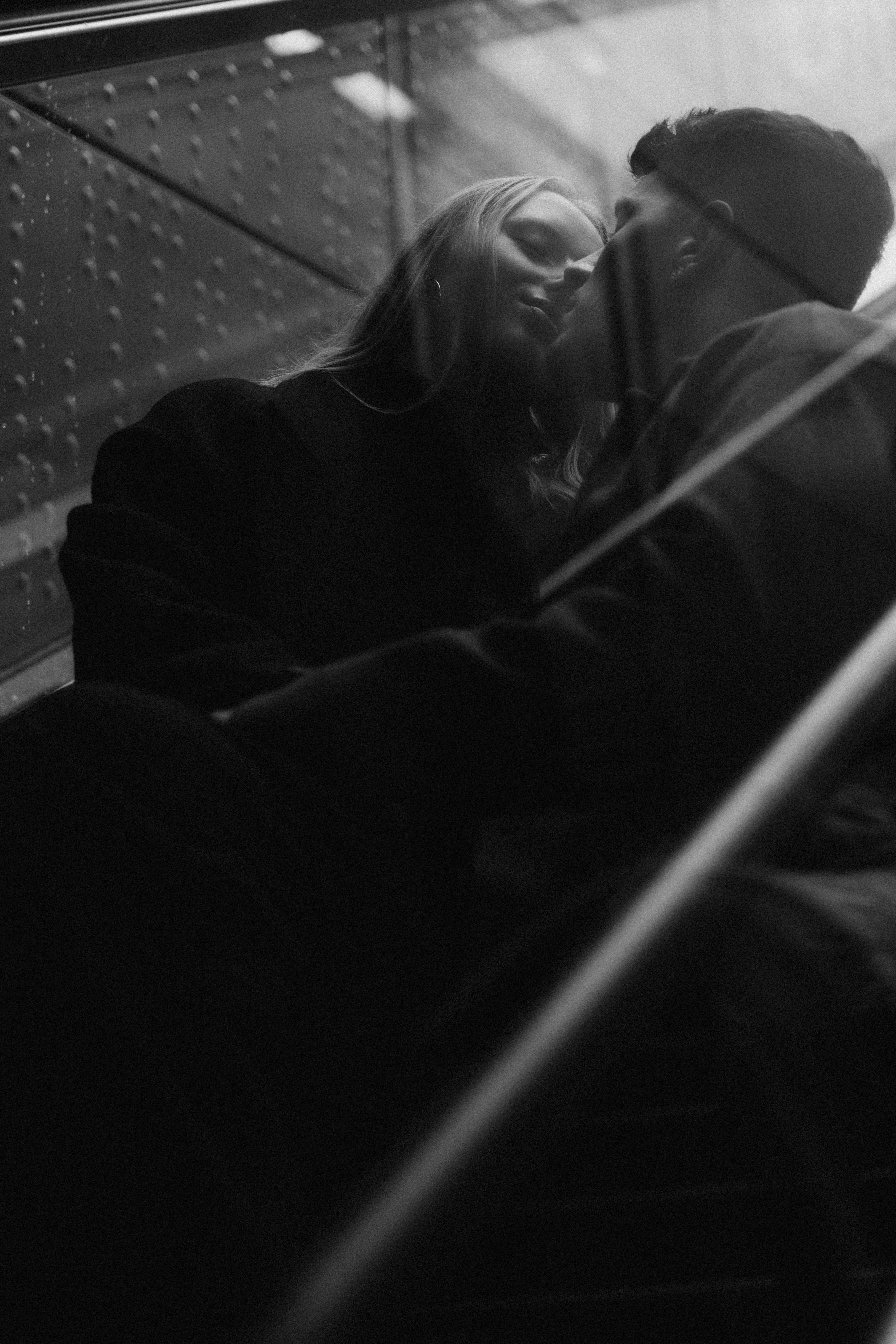 Intimate black and white photo of a couple kissing on stairs in Düsseldorf.