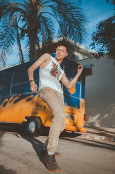 时尚的年轻人在棕榈树下，自信地在一辆充满活力的货车前摆出姿势