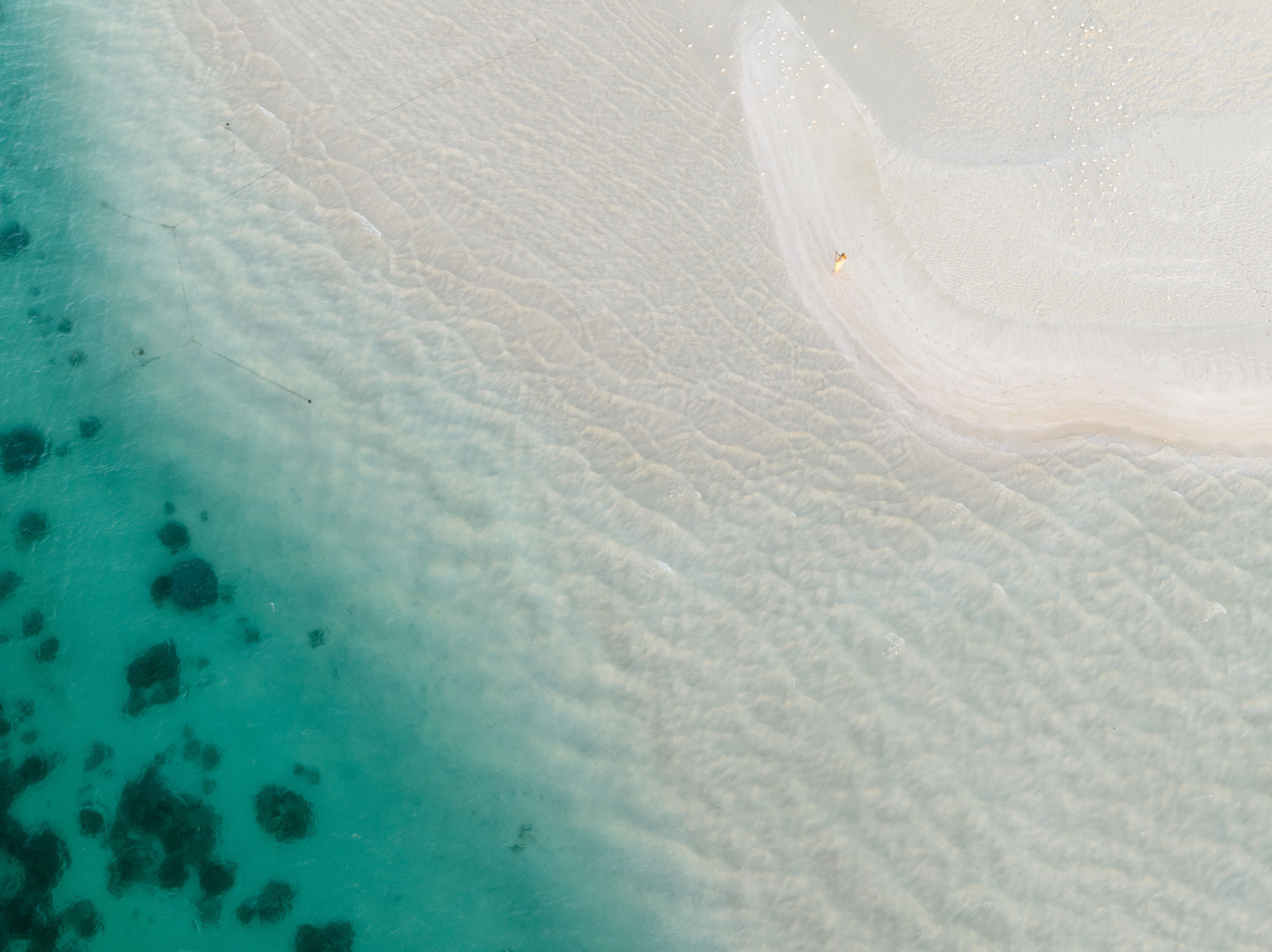 Gold Coast Helicopter 10 min Flight and Jet Boat Ride - Stunning aerial view of Coral Bay, WA showcasing turquoise waters and white sandy beach.