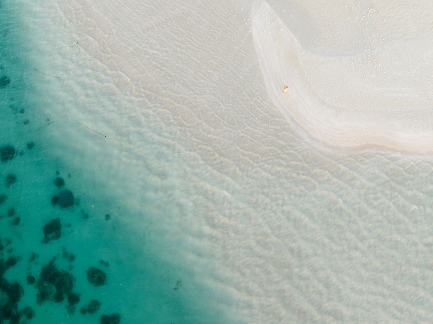 Gold Coast Helicopter 10 min Flight and Jet Boat Ride - Stunning aerial view of Coral Bay, WA showcasing turquoise waters and white sandy beach.