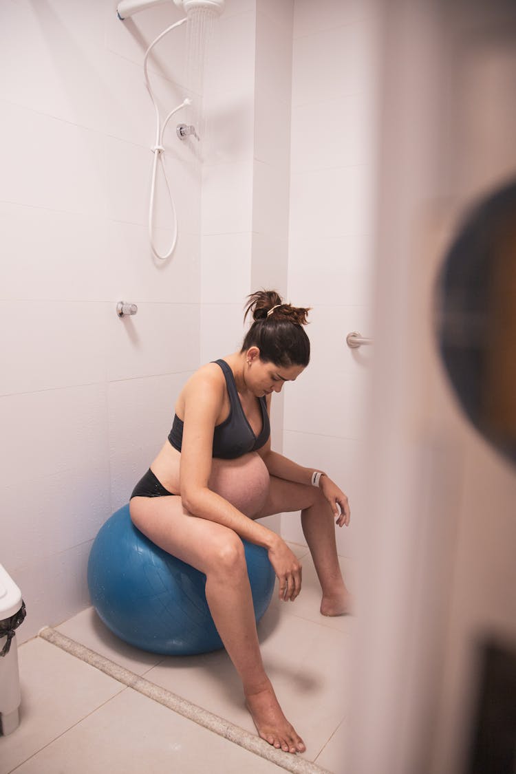 Pregnant Woman Sitting On A Exercise Ball In The Shower