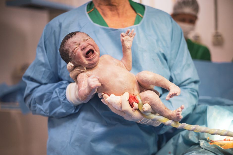 Obstetricians Explained: Your Guide to Pregnancy and Postnatal Care doctor holding a newborn baby - obstetrician