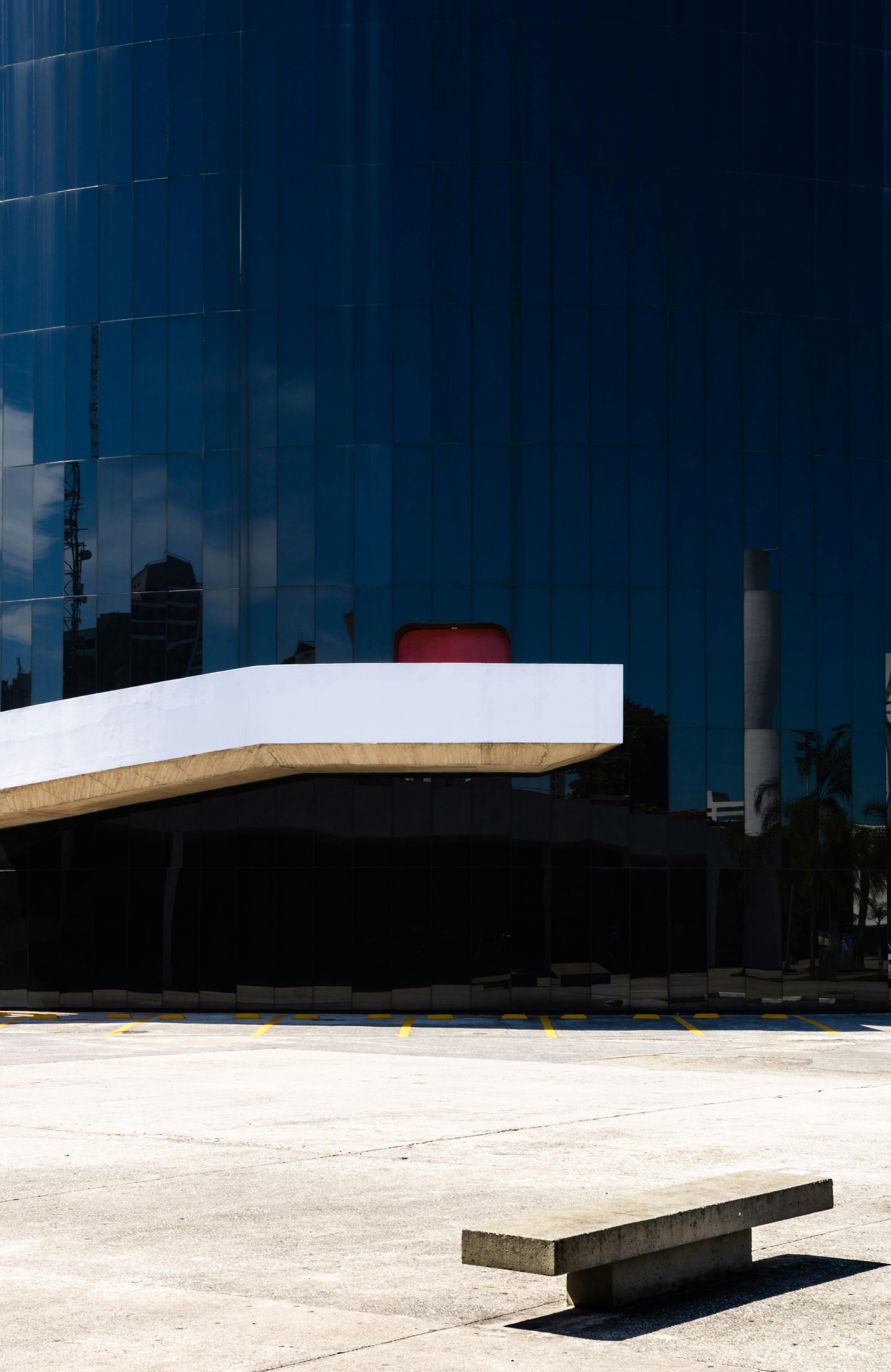 一座现代建筑，拥有反光玻璃立面和空旷的室外区域