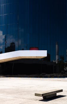 一座现代建筑，拥有反光玻璃立面和空旷的室外区域