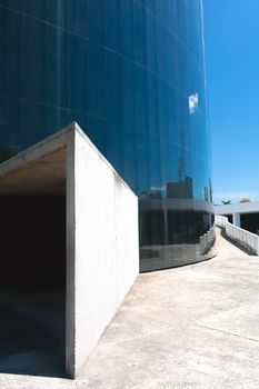 在晴朗的蓝天下，一座拥有反光玻璃和干净混凝土线条的现代建筑引人注目