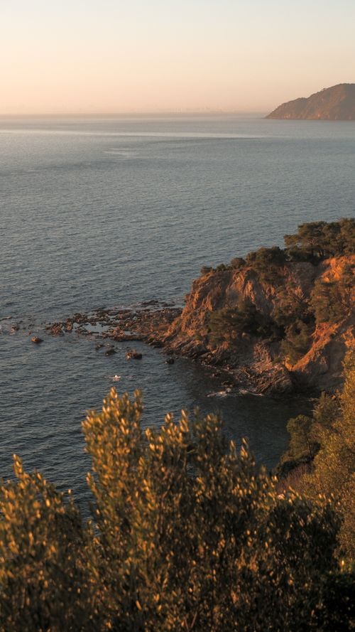Free Dramatic view of a coastal cliff with the sea at sunset, capturing tranquil beauty. Stock Photo