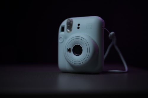 Free A close-up of a sleek instant camera against a black background, highlighting its modern design. Stock Photo