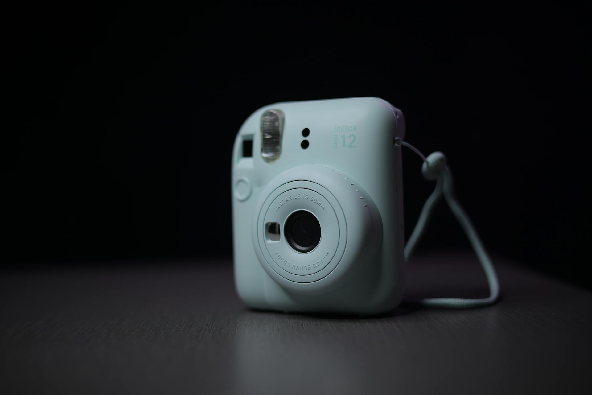 Studio shot of a Fujifilm Instax Mini 12 instant camera highlighting its design and features.