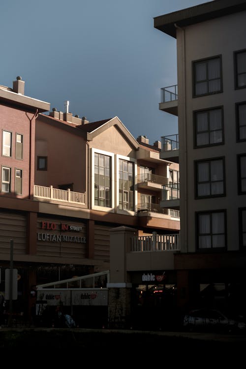 Facades of Buildings with Shops in City under Blue Sky 