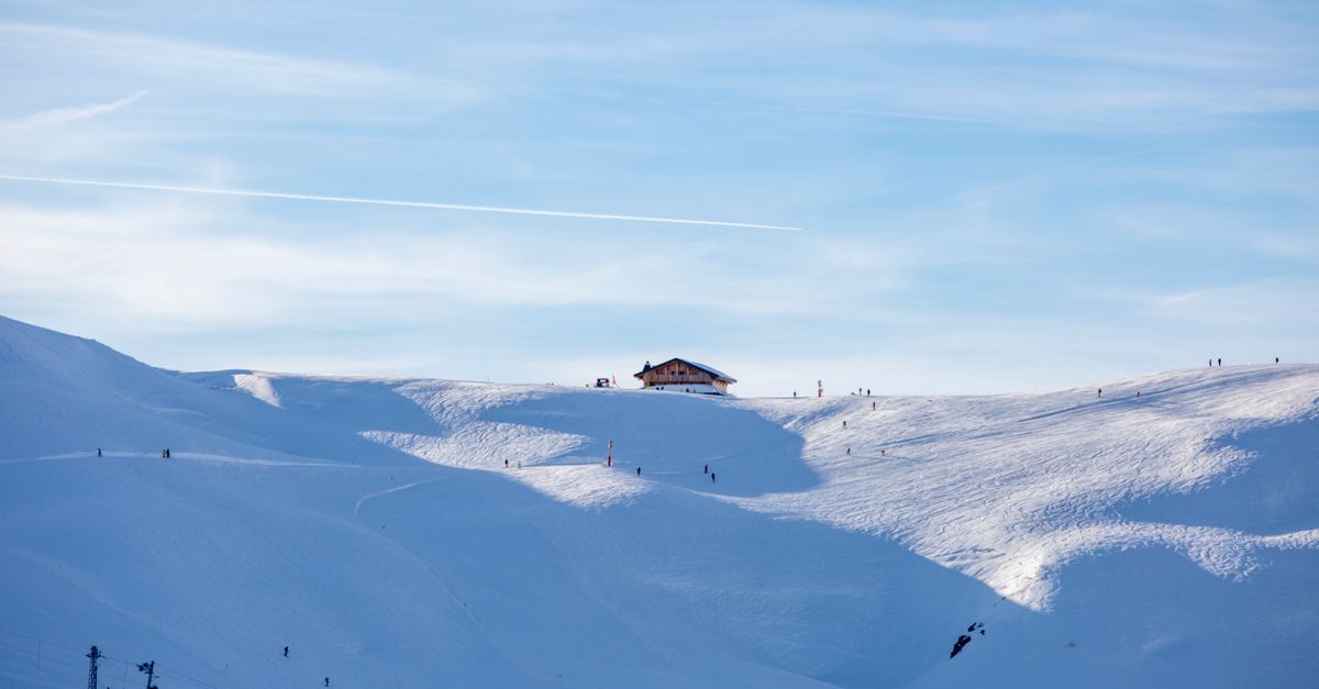 Stunning winter landscape of Les Contamines-Montjoie ski resort in France with skiers on snowy slope
