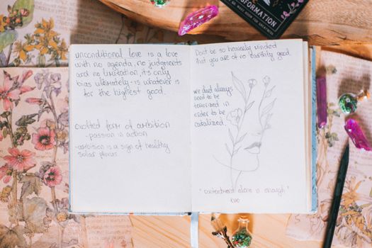 A notebook with a pen and flowers on it