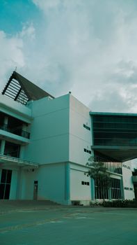 A contemporary building featuring solar panels under a cloudy sky, highlighting modern architecture. - Fotografer Sidoarjo