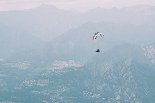 A Person Paragliding in Mountains