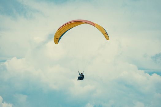 A thrilling paragliding experience high above the clouds on a sunny day.