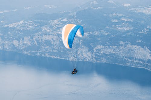 A Person Paragliding Above a Lake