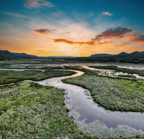 Free A breathtaking sunset over the tranquil river bend in Weaver, Minnesota's lush landscape. Stock Photo