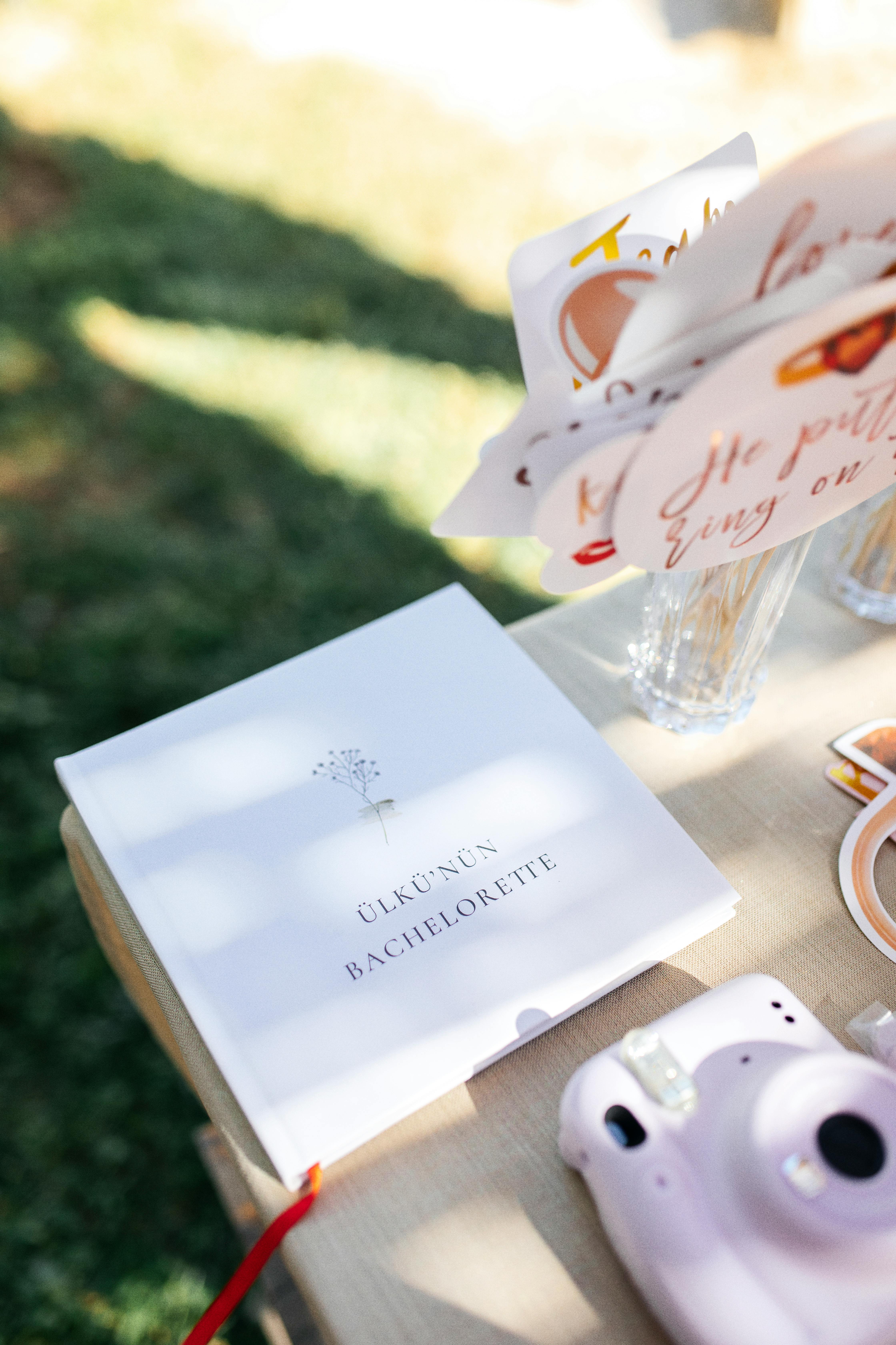 Close-up of bachelorette party decorations with instant camera on outdoor table.